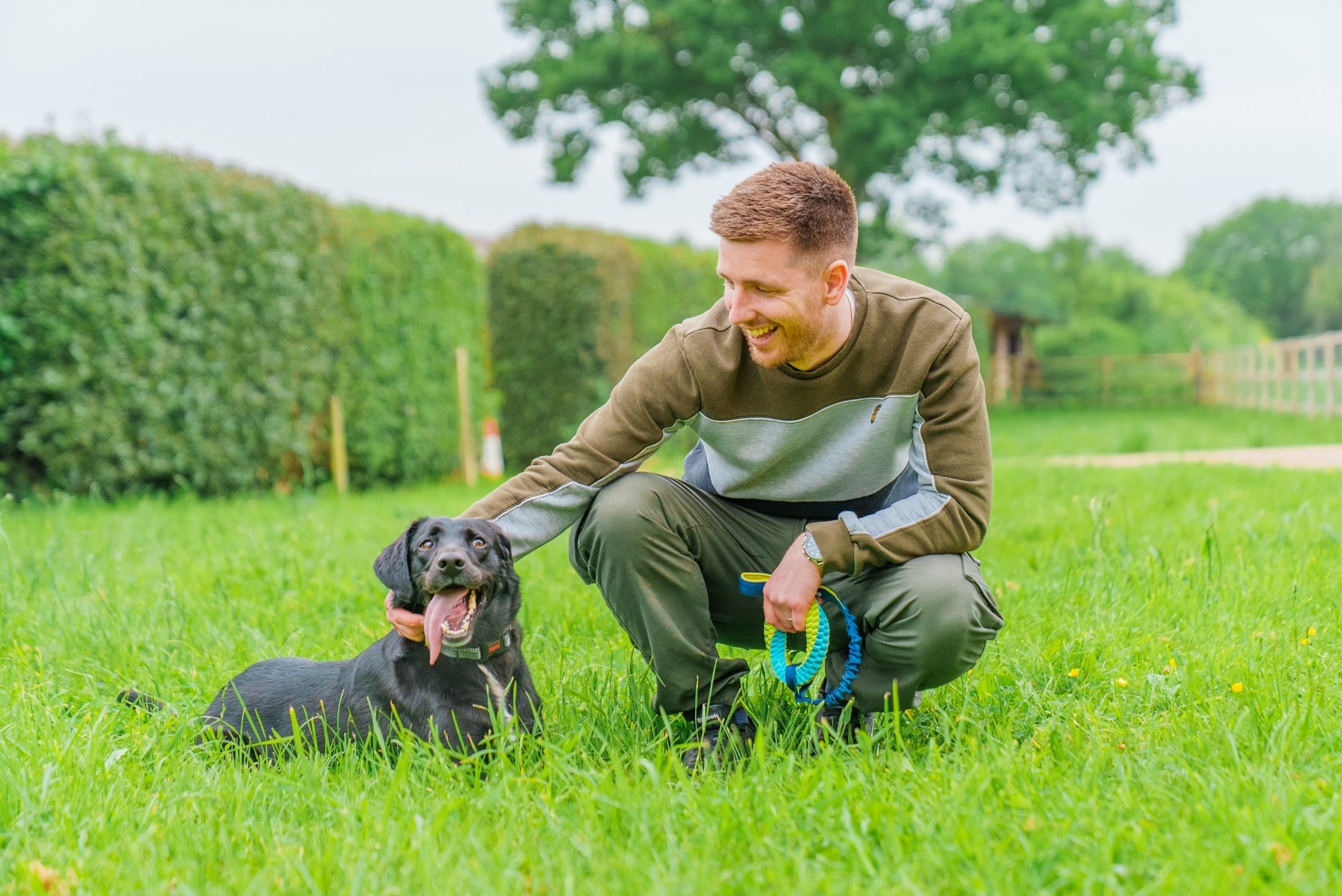 A man and his dog use a Coachi tug toy for a fun training session